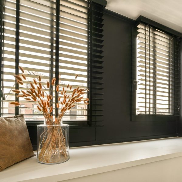 some flowers in a vase on a window sie with black shutters and white trim around the windowsill